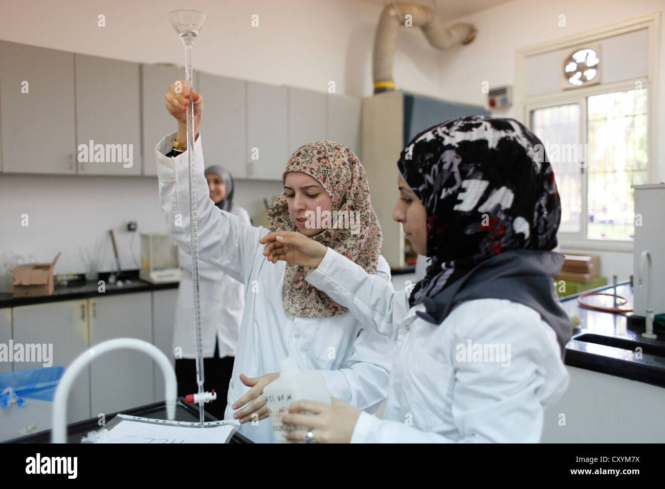 Palästinensische Studentinnen in Laborkittel arbeiten an Experimenten in einem Chemiebildungslabor an der Al Quds Universität in Abu Dis oder Abu Dis, einer palästinensischen Gemeinde, die zum palästinensischen Gouvernement Jerusalem südöstlich von Jerusalem in Israel gehört Stockfoto