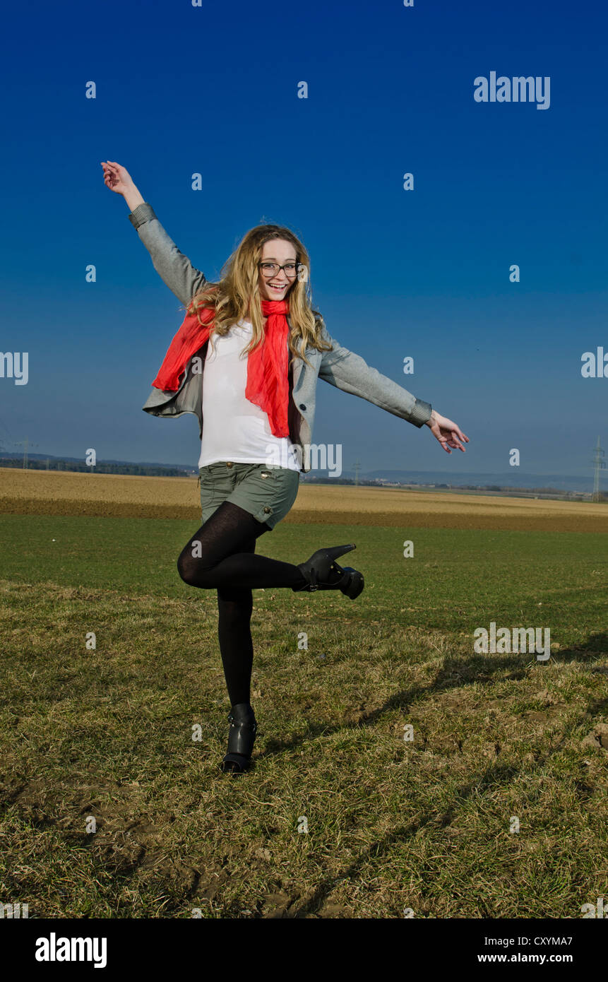 Junge Frau, 25, trägt einen roten Schal auf freiem Feld Stockfoto