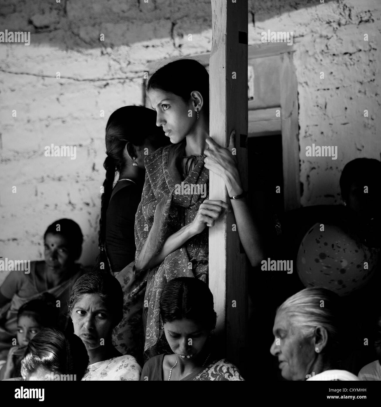 Aufmerksame junge Frau im Publikum während Theyyam Zeremonie, Thalassery, Indien Stockfoto
