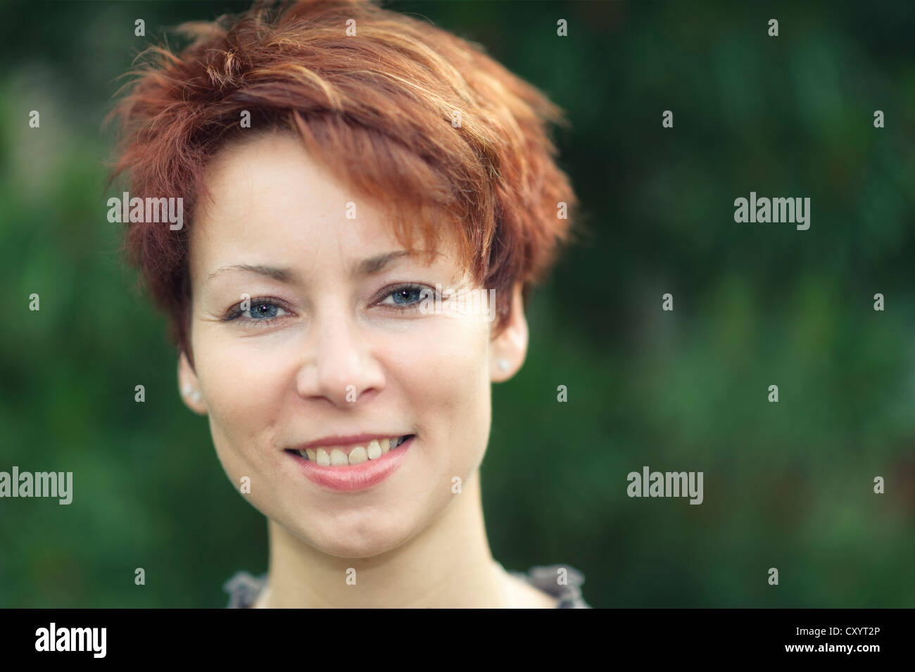 Lächelnde junge Frau mit kurzen roten Haaren, Porträt Stockfoto
