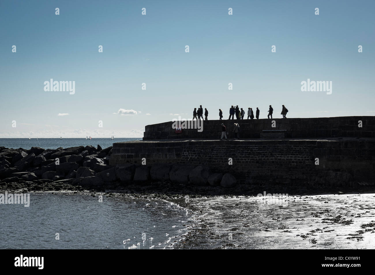 Silhouette von Lyme Regis berühmtem Cobb, Dorset, Großbritannien mit Touristen und Menschen, die die Aussicht genießen Stockfoto
