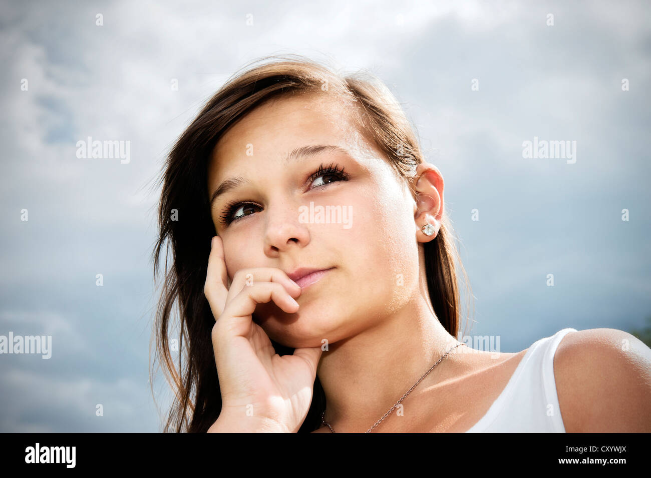 Mädchen, 14 Jahre, blickte nachdenklich vor Wolkenhimmel Stockfoto