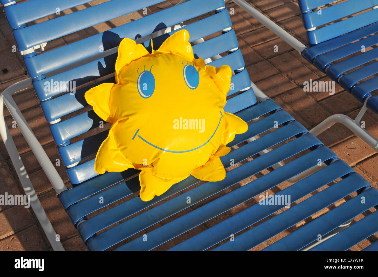 Spielzeug-Sonne auf einer Liege liegend Stockfoto