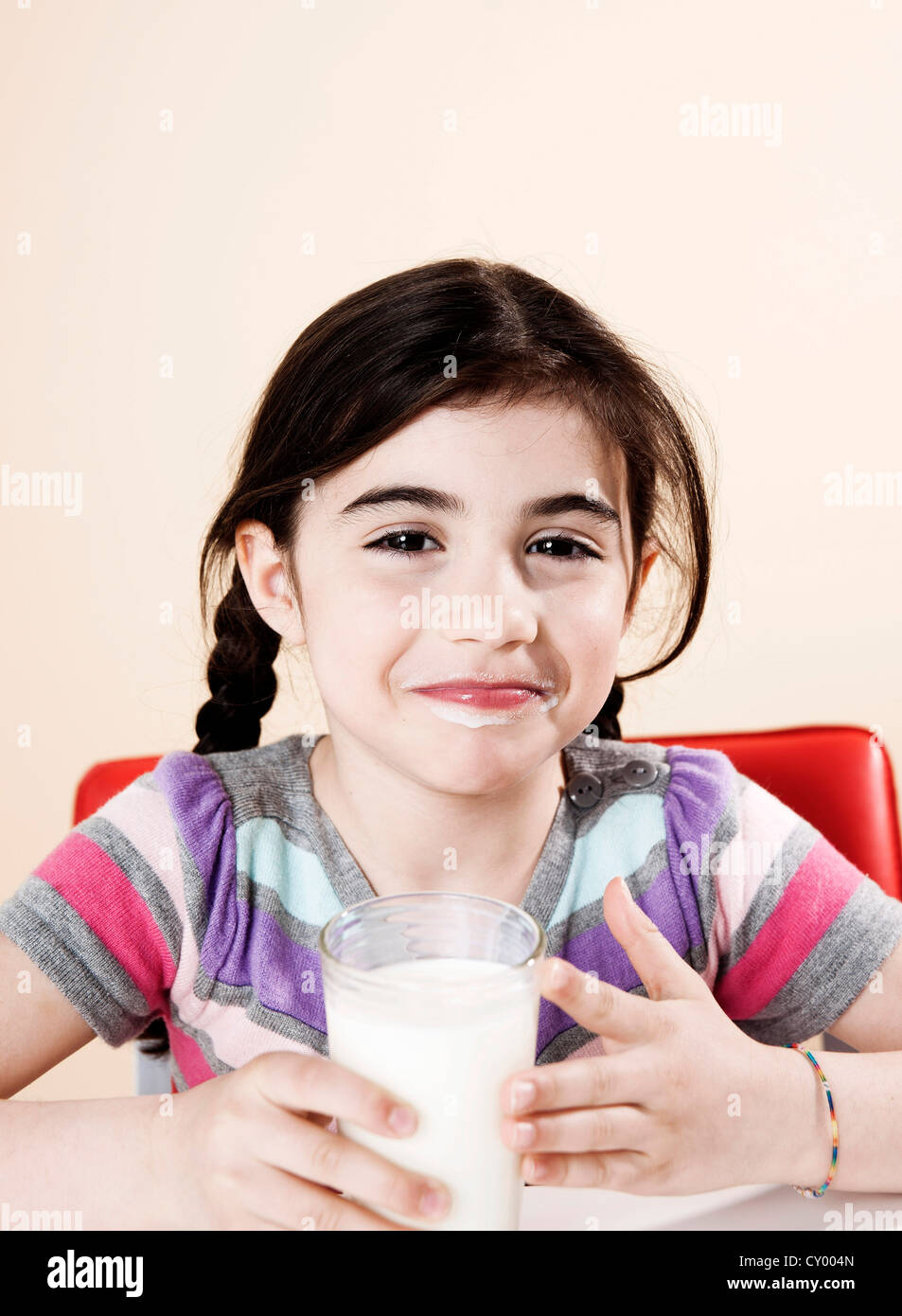 Lächelndes Mädchen mit einem Glas Milch in der hand Stockfoto