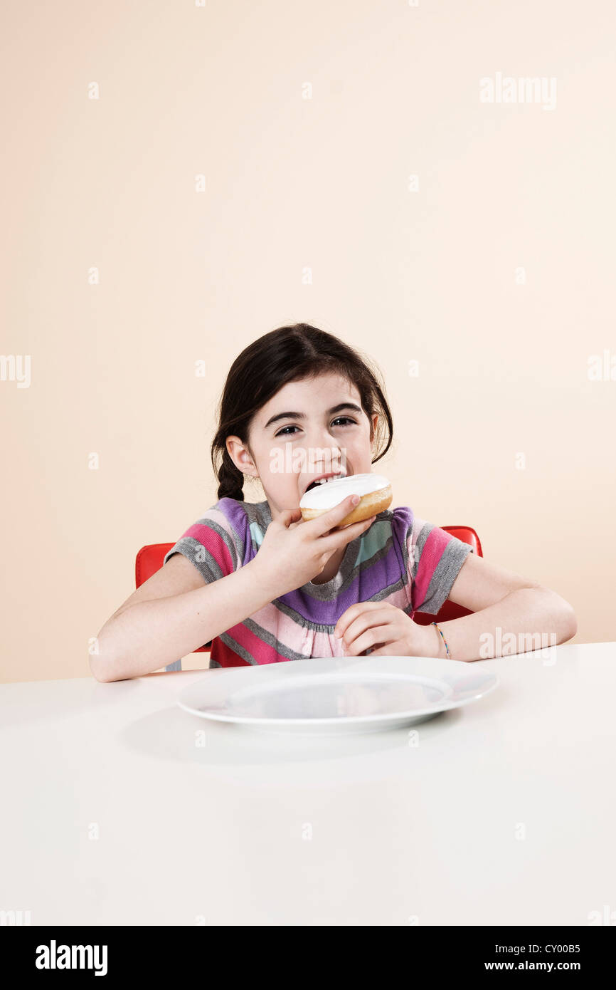 Mädchen gierig Essen einen donut Stockfoto