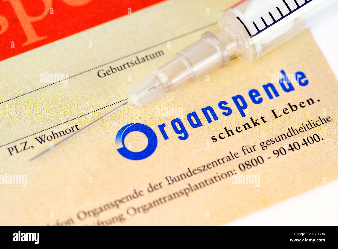 Spritze auf einen Organspendeausweis, symbolisches Bild für Organspende