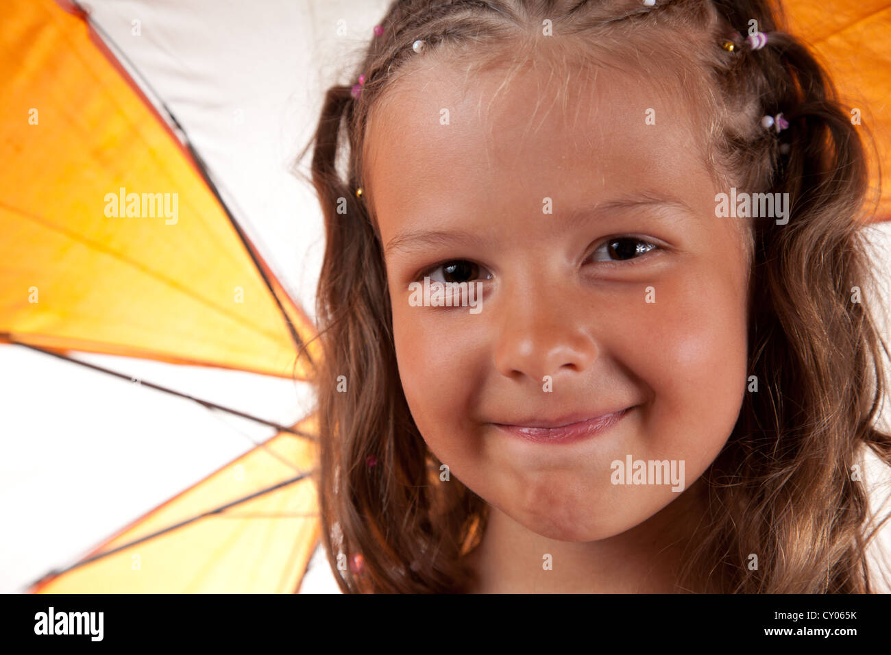 Nahaufnahme der niedliche kleine Mädchen mit orange Regenschirm Stockfoto