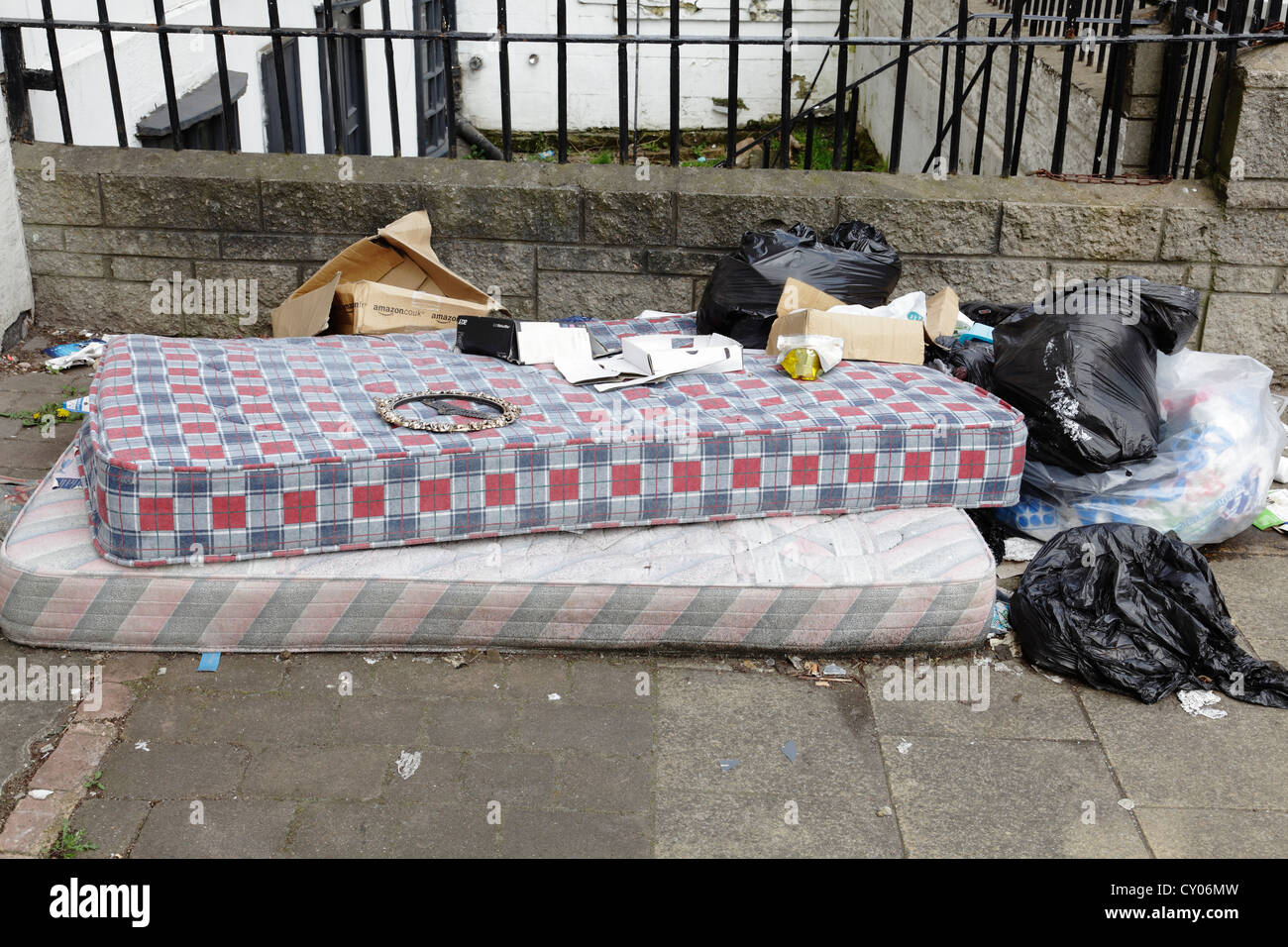 Eine Matratze und andere Haushaltsgegenstände verworfen, in einer Straße von Glasgow in Schottland, Großbritannien Stockfoto
