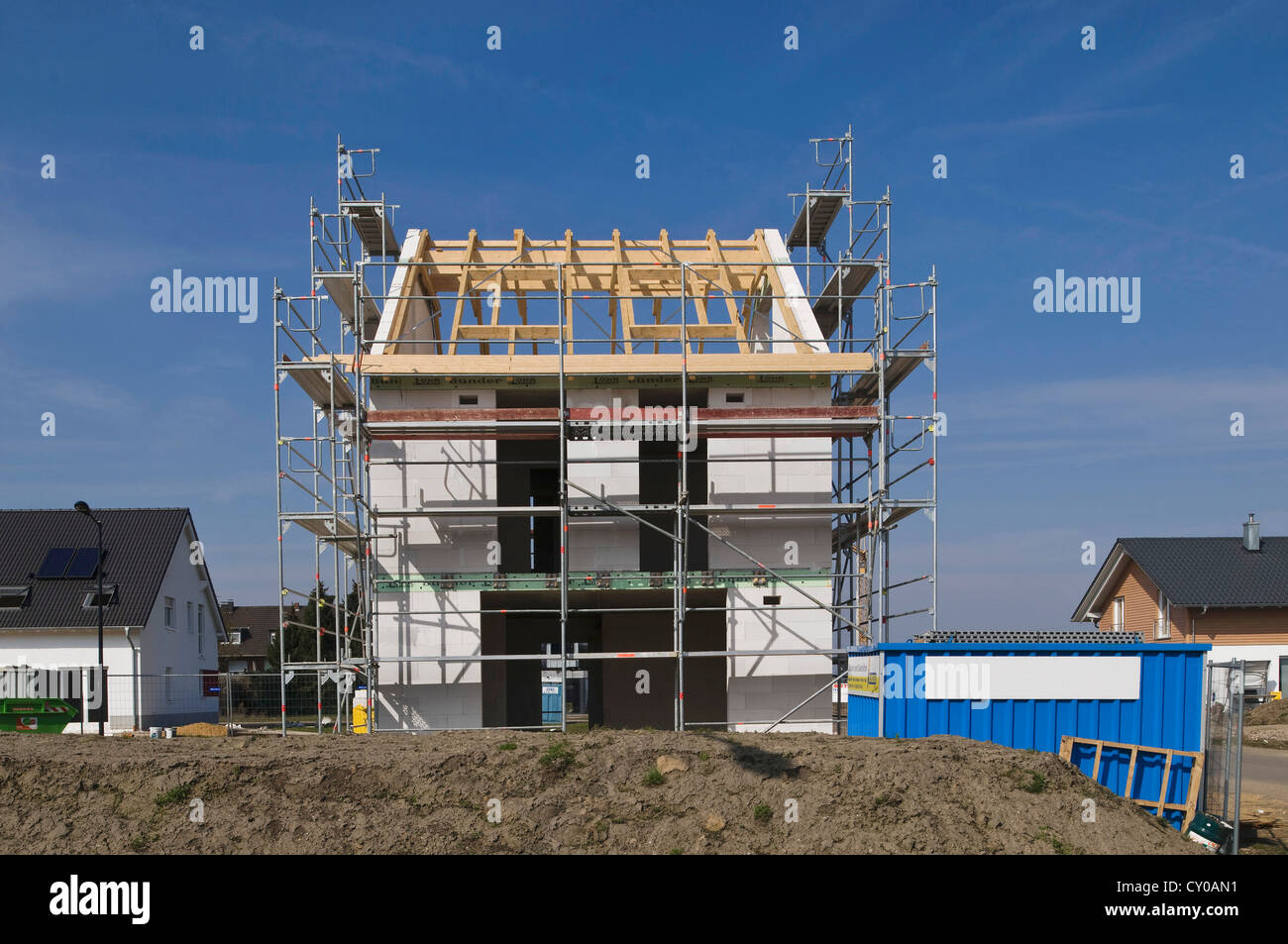 Neubaugebiet, Baustelle, Einfamilienhaus mit Gerüst vor abgeschlossenen Häusern umgeben Stockfoto