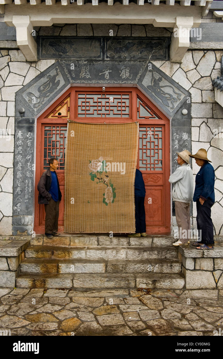 Arbeiter spähen hinter einem Vorhang im San Huang Zhai Kloster auf dem Song-Berg, China Stockfoto