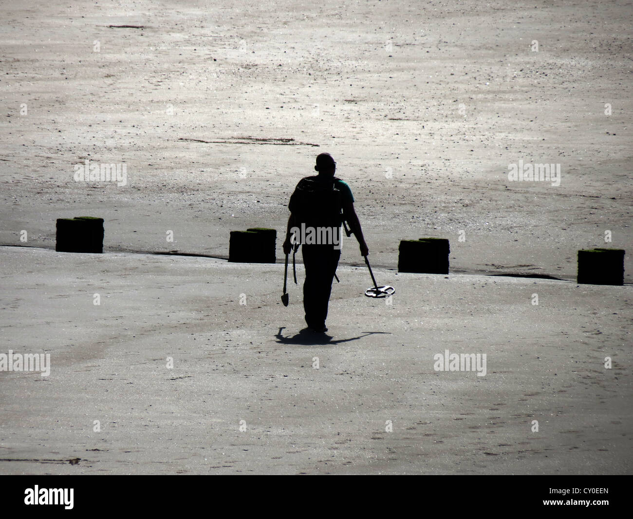 Mann am Strand mit Metalldetektor. Stockfoto