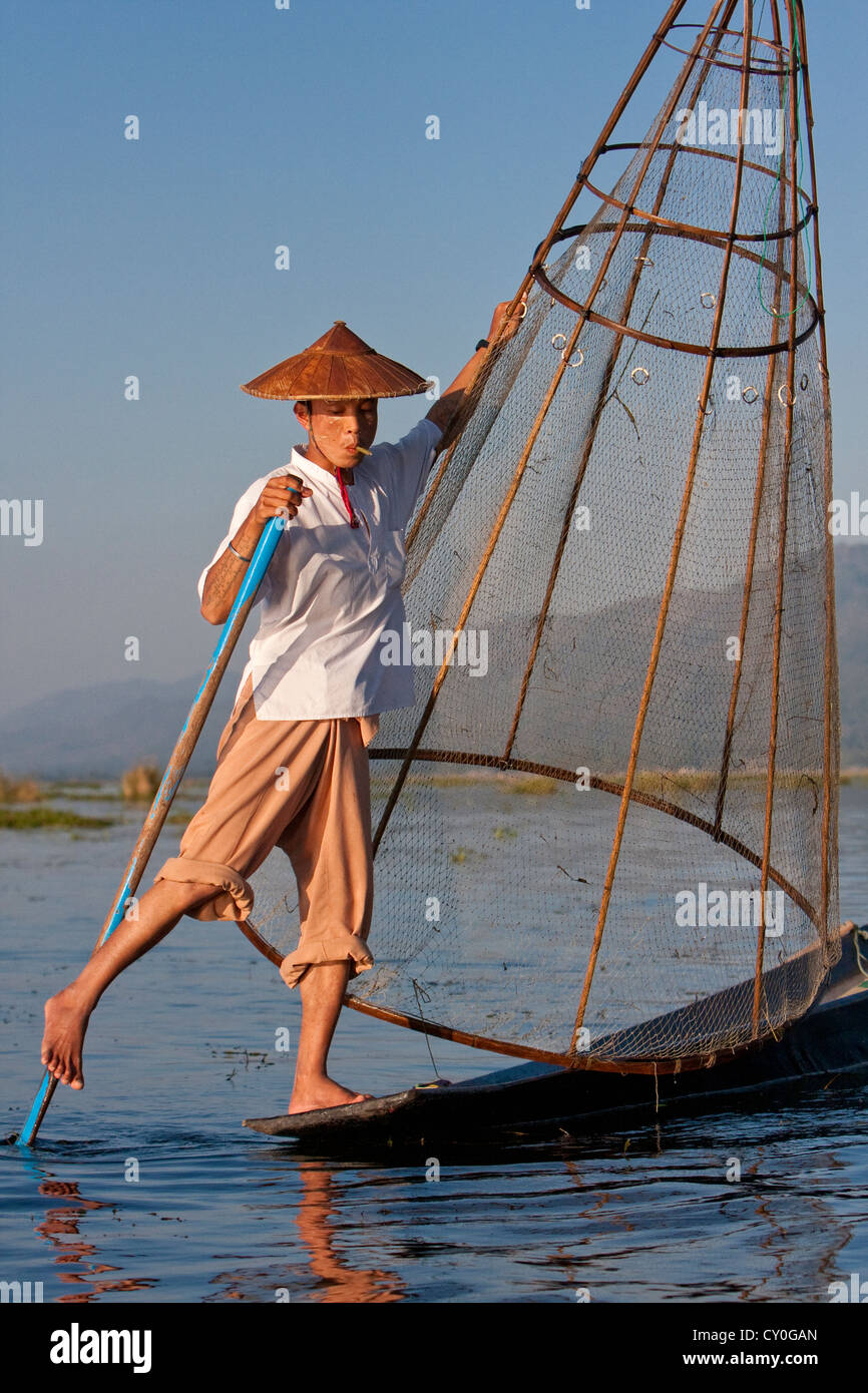Myanmar, Burma. Fischer, die Suche nach einem Ort zu sein Netz beim Rudern mit einem Bein in der Stil zum Inle See. Stockfoto