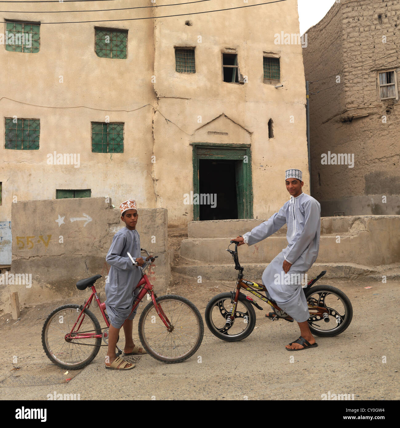 Zwei jungen Reiten Fahrräder vor der Residenz, Nizwa, Oman Stockfoto