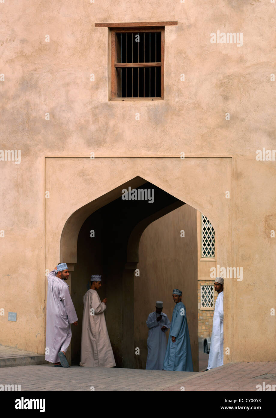 Muslimische Männer sammeln unter der Tür im arabischen Stil, Nizwa, Oman Stockfoto