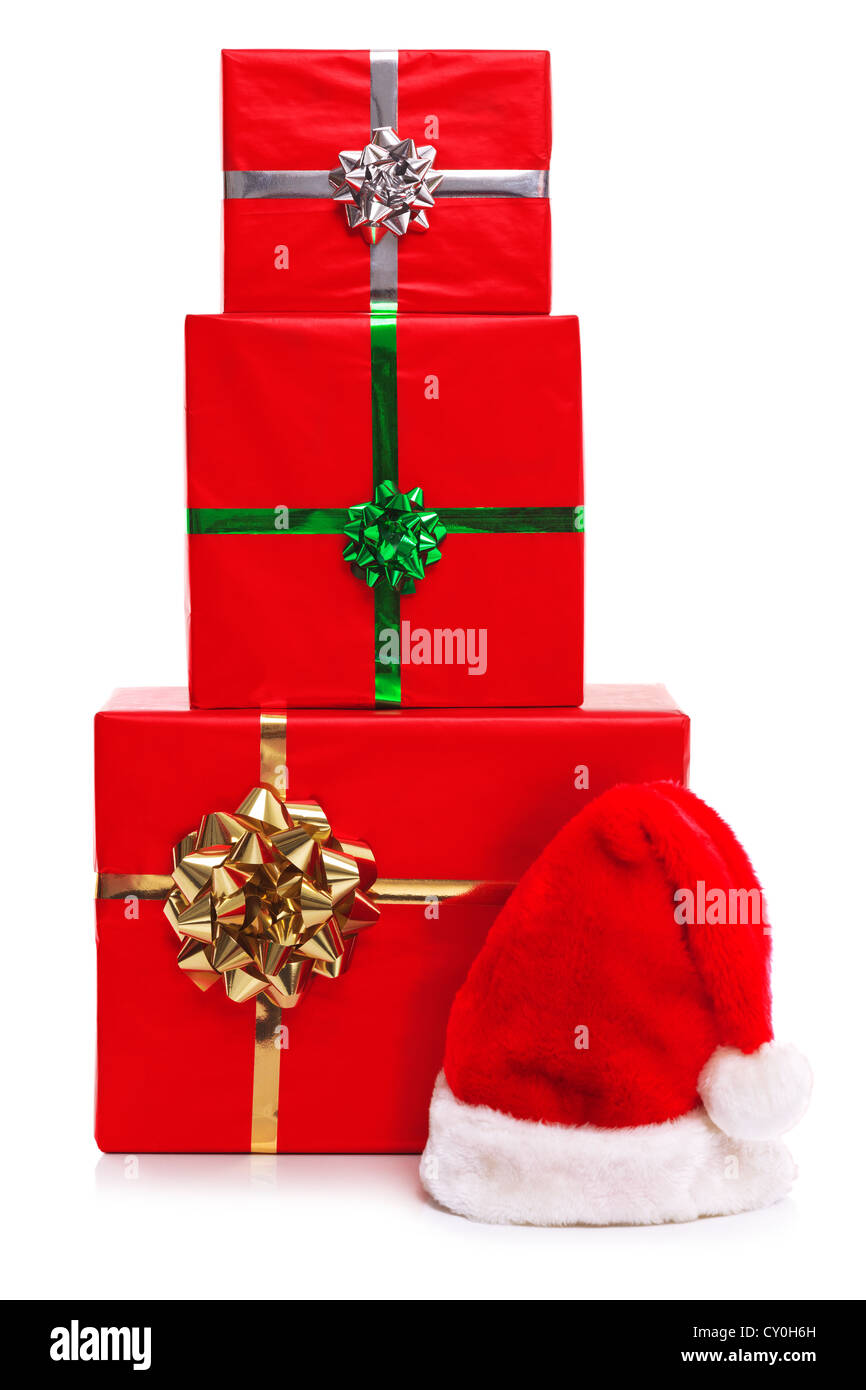 Weihnachtsmann-Mütze und drei roten Geschenk verpackt Weihnachtsgeschenke mit Bändern und Schleifen, isoliert auf einem weißen Hintergrund. Stockfoto