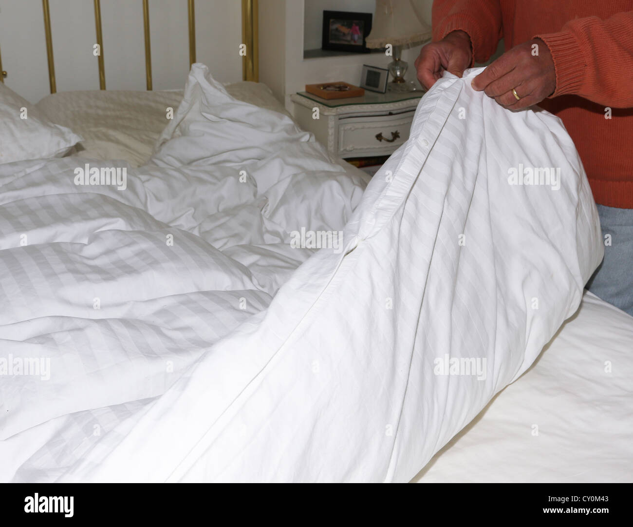 Man ändert das Bett Bettwäsche nehmen der Bettbezug Stockfoto