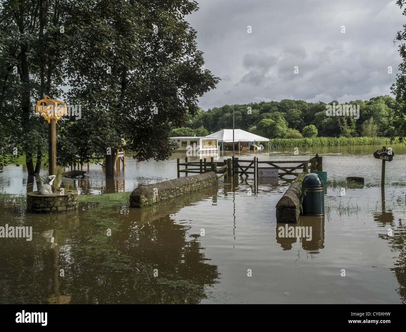 Starkregen flutet Parkland und Ruinen Sommer Dorffest als River Torridge seinen Ufern platzt. Weare Gifford, Devon. UK Stockfoto