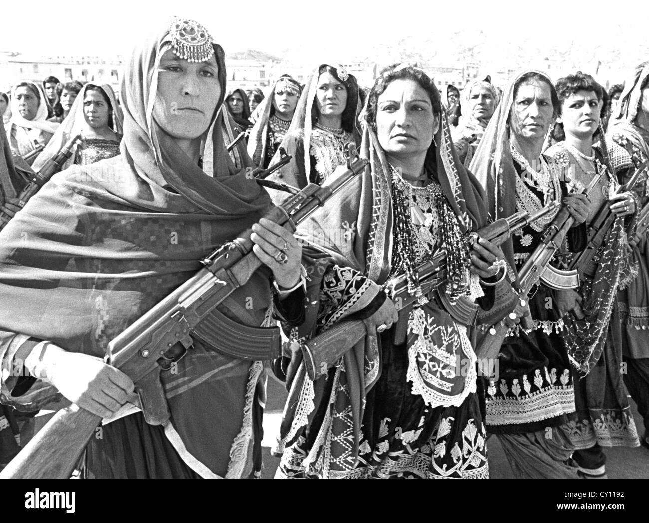 Afghanische Frauen-Dorf-Verteidigung-Kräfte in traditionellen Stammes-Kostüm tragen sowjetischen AK-47 während einer Parade anlässlich des 10. Jahrestages der kommunistischen Revolution 26. April 1988 in Kabul, Afghanistan. Stockfoto