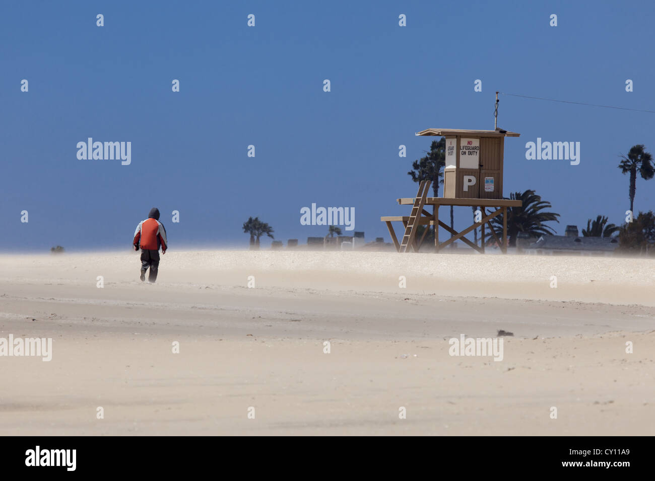 Einsame Person entlang der Strand mit Sand weht an windigen Tag Balboa Halbinsel, Newport Beach, Southern California, USA Stockfoto