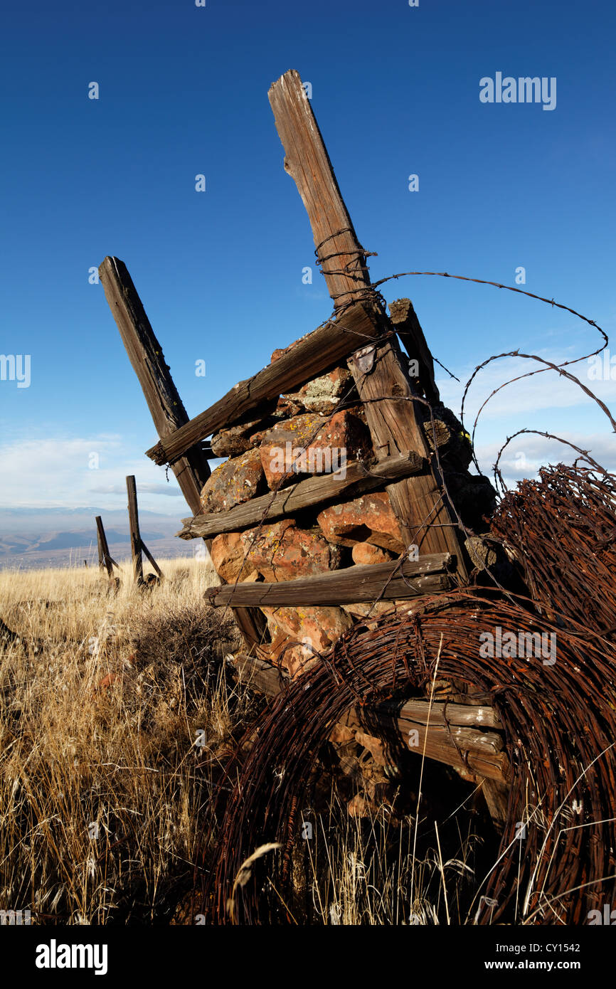 Ein Rock-Jack Anker einen Stacheldrahtzaun in steinigen Wüstengebiet, Yakima Rim Skyline Trail, Yakima, Washington Stockfoto