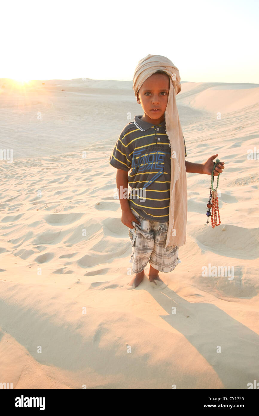 Tunesische junge wartet auf Touristen in der Sahara, in einem touristischen Punkt, so dass er einige Souvenirs verkaufen konnte. Stockfoto