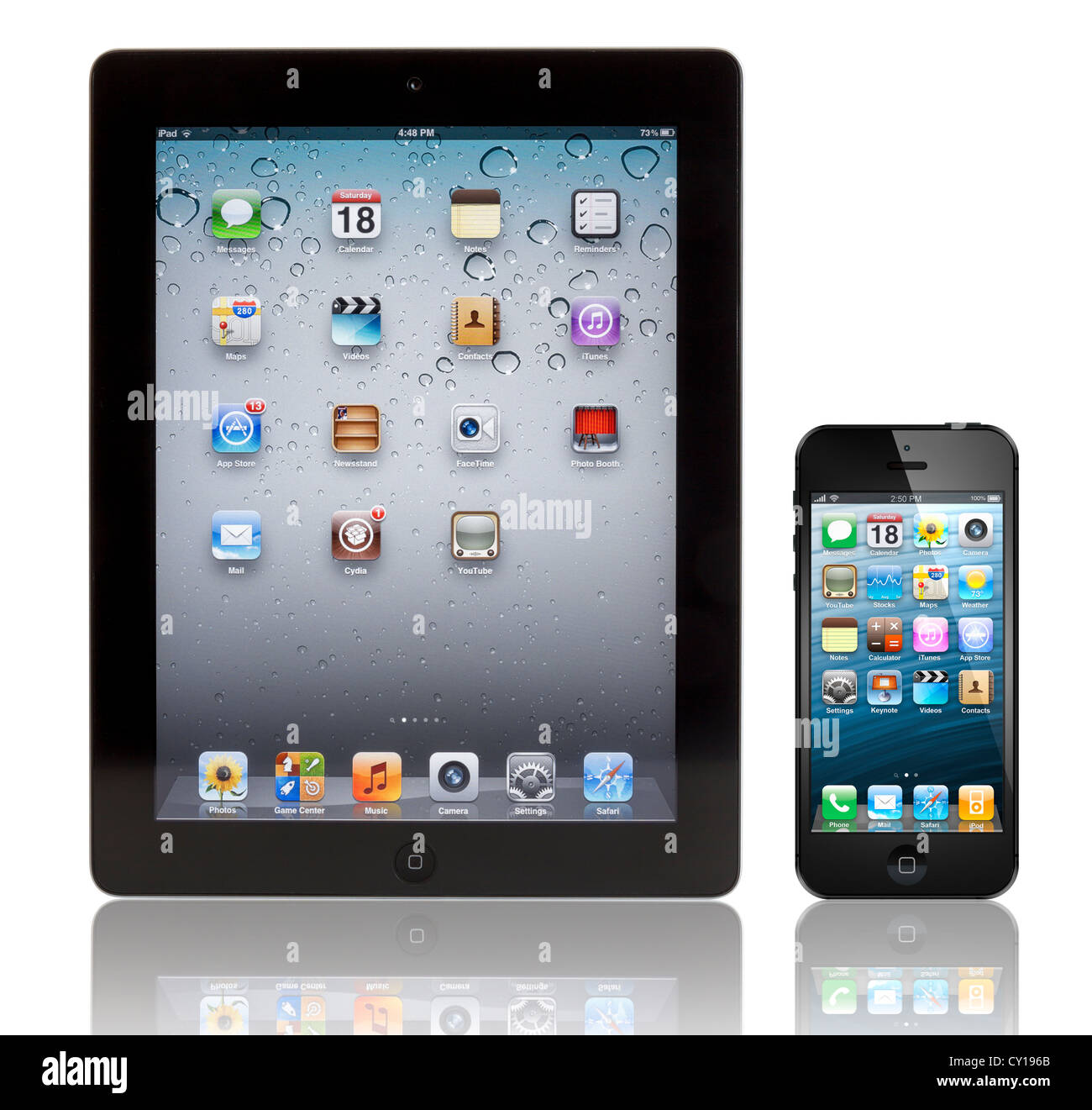 Ein schwarzes Apple iPhone 5 vor einem schwarzen Apple iPad 3 Tablet. Beide Geräte zeigen die Homepage. Stockfoto