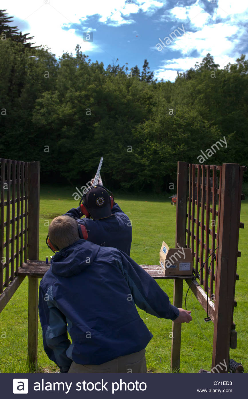 Ein Mann wird in der Sportart Tontaubenschießen angewiesen. Stockfoto