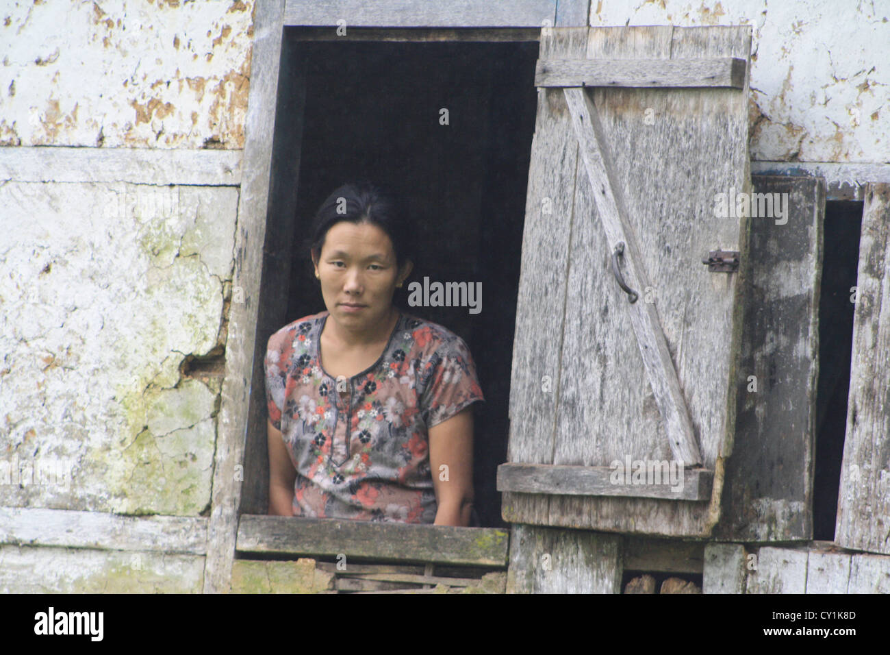 Lepcha Frauen Blick aus ihrem Fenster in West Sikkim nahe Pelling. Stockfoto
