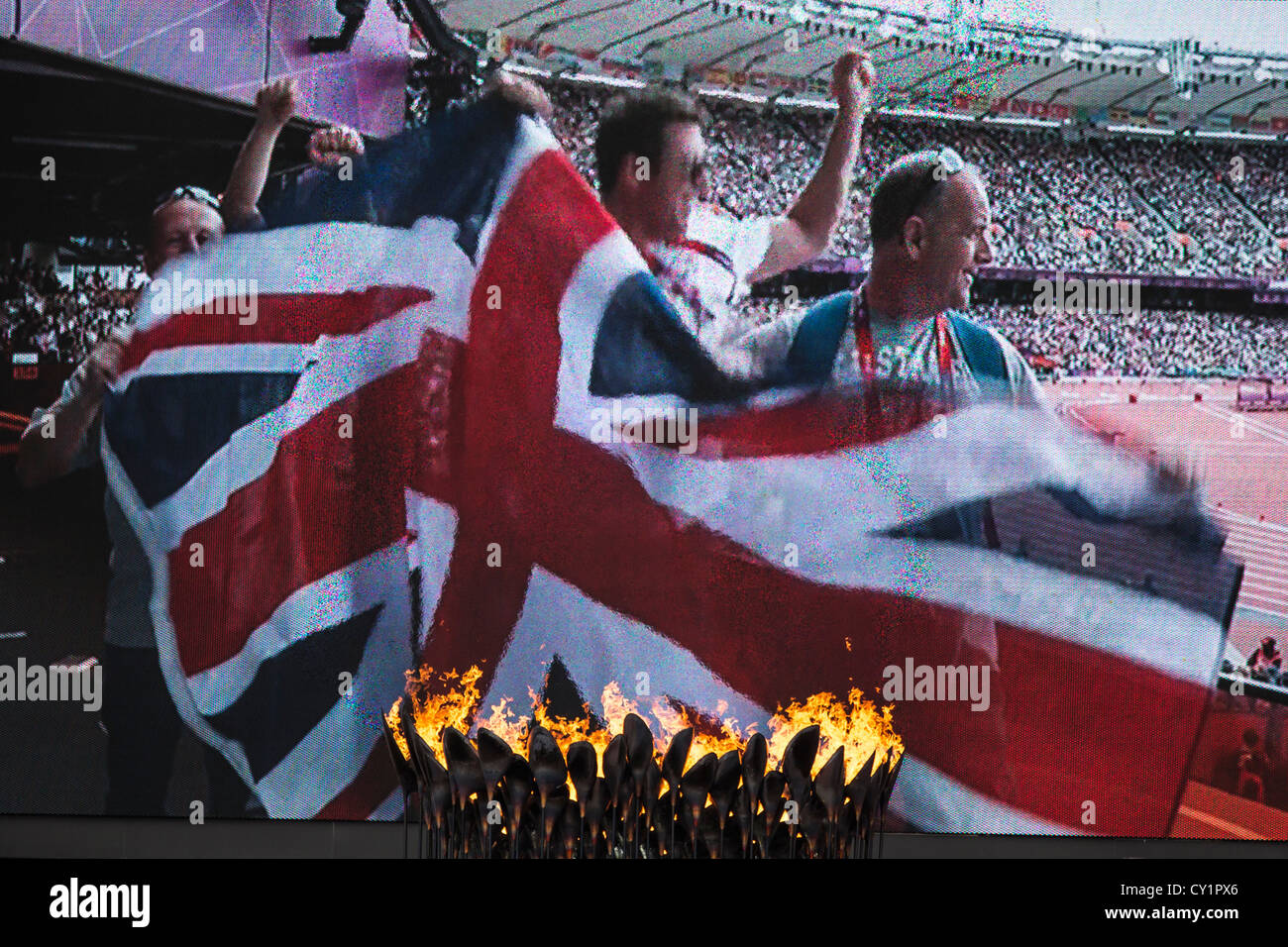 Britische Fans gezeigt Celebratiing auf der großen Videoleinwand mit Blick auf die Flamme zu den Olympischen Sommerspielen 2012 in London Stockfoto