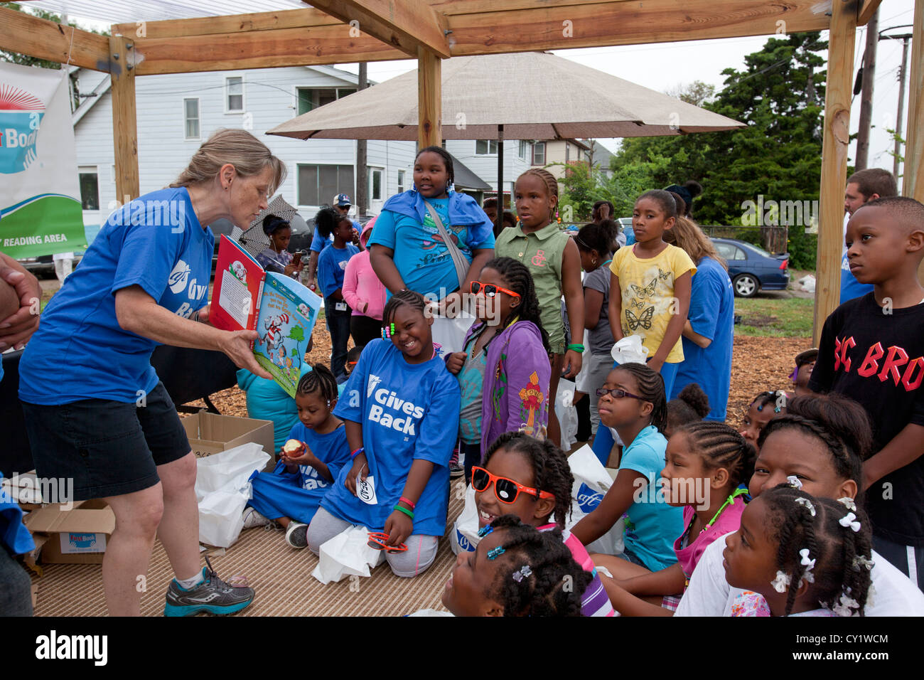 Detroit, Michigan - Freiwillige aus der American Federation of Teachers lesen Bücher für Kinder in einem Gemeinschaftsgarten. Stockfoto