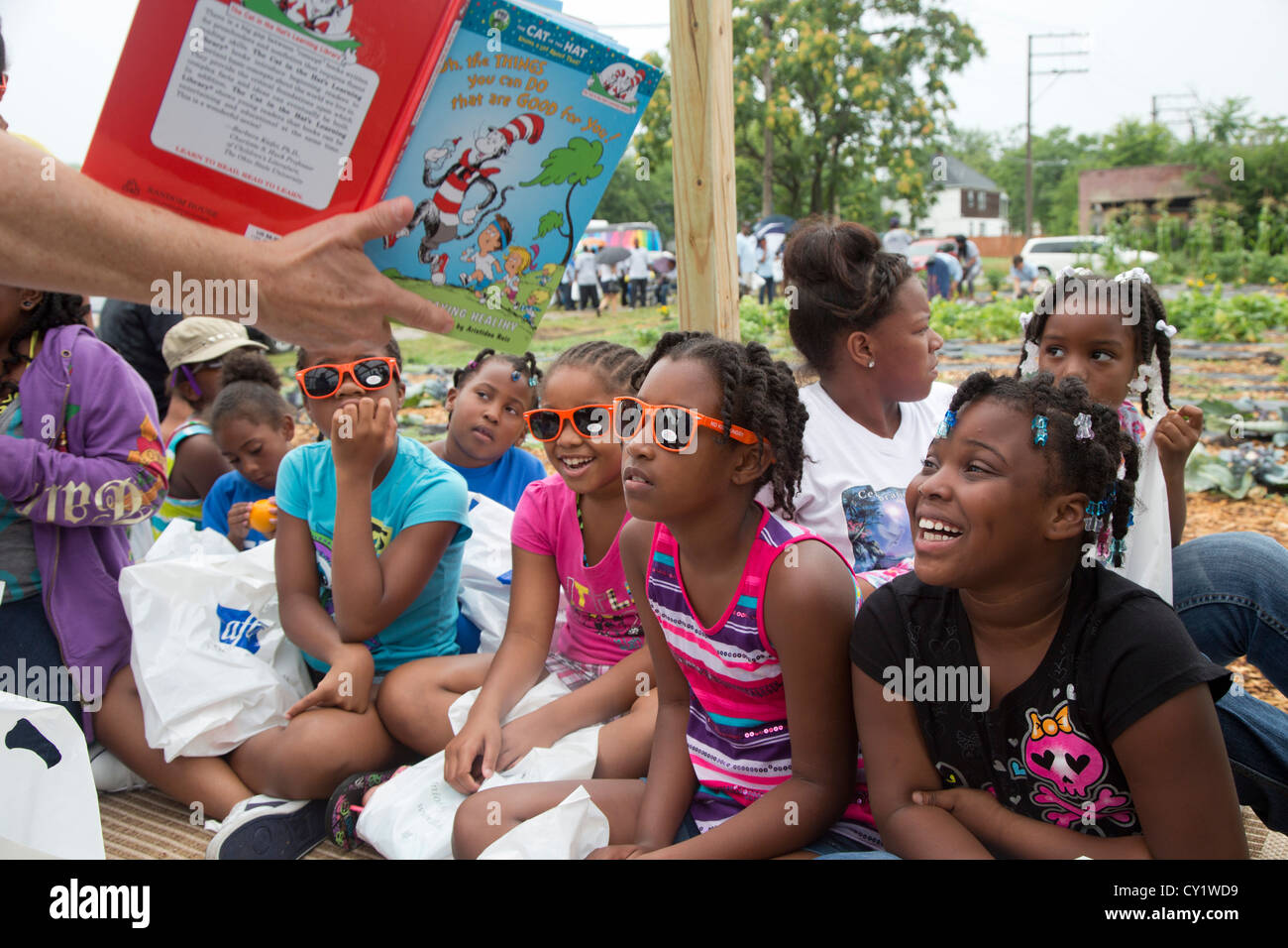 Detroit, Michigan - Freiwillige aus der American Federation of Teachers lesen Bücher für Kinder in einem Gemeinschaftsgarten. Stockfoto
