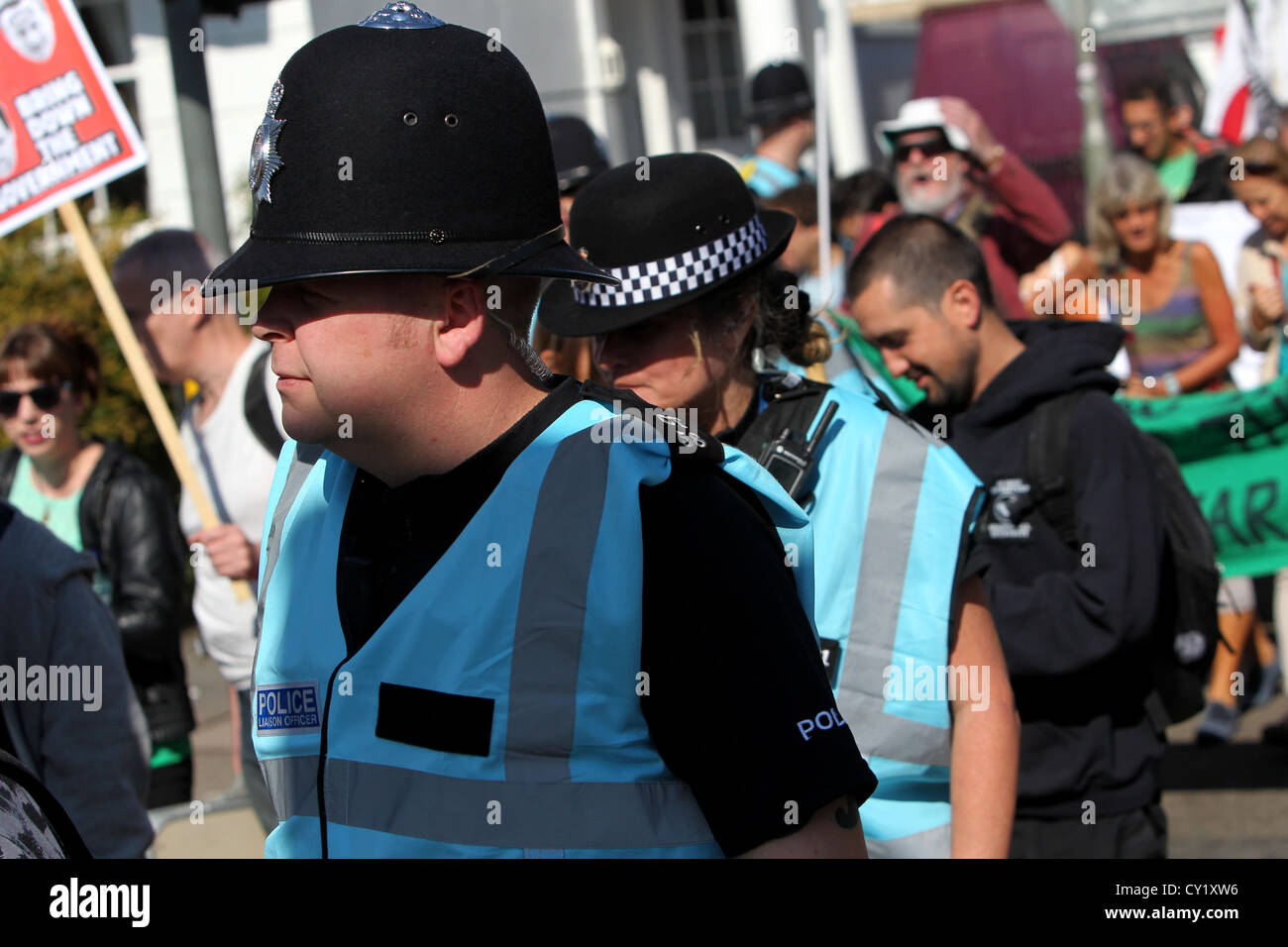 Polizei-Verbindungsbeamten tragen neue leichte blaue High-Vis Jacken und mischen mit Demonstranten während einer Protestaktion in Brighton, Sussex. Stockfoto