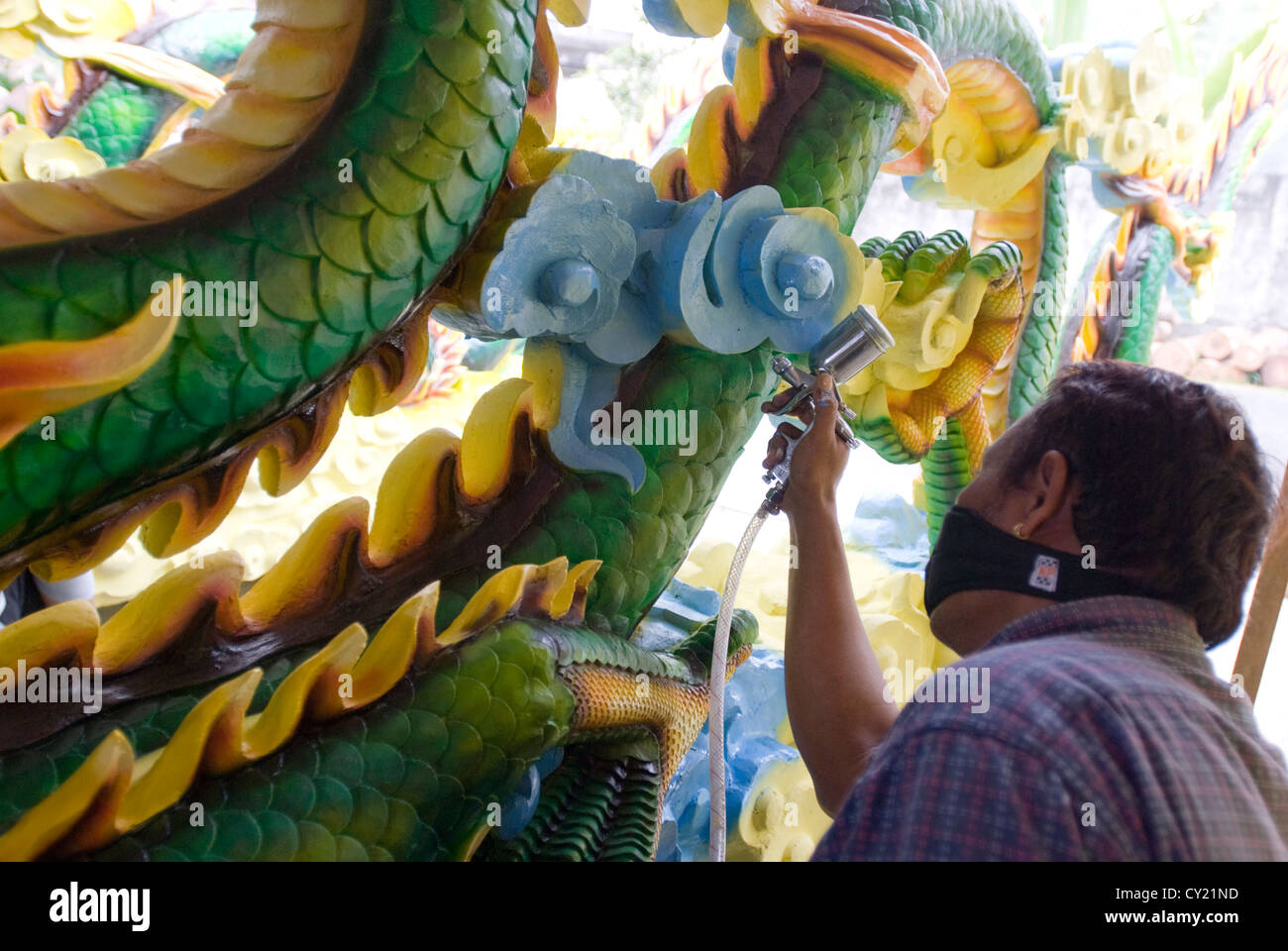 Ein Künstler Spraypaints eine ornamentale Drachen in Ubud, Bali, Indonesien Stockfoto
