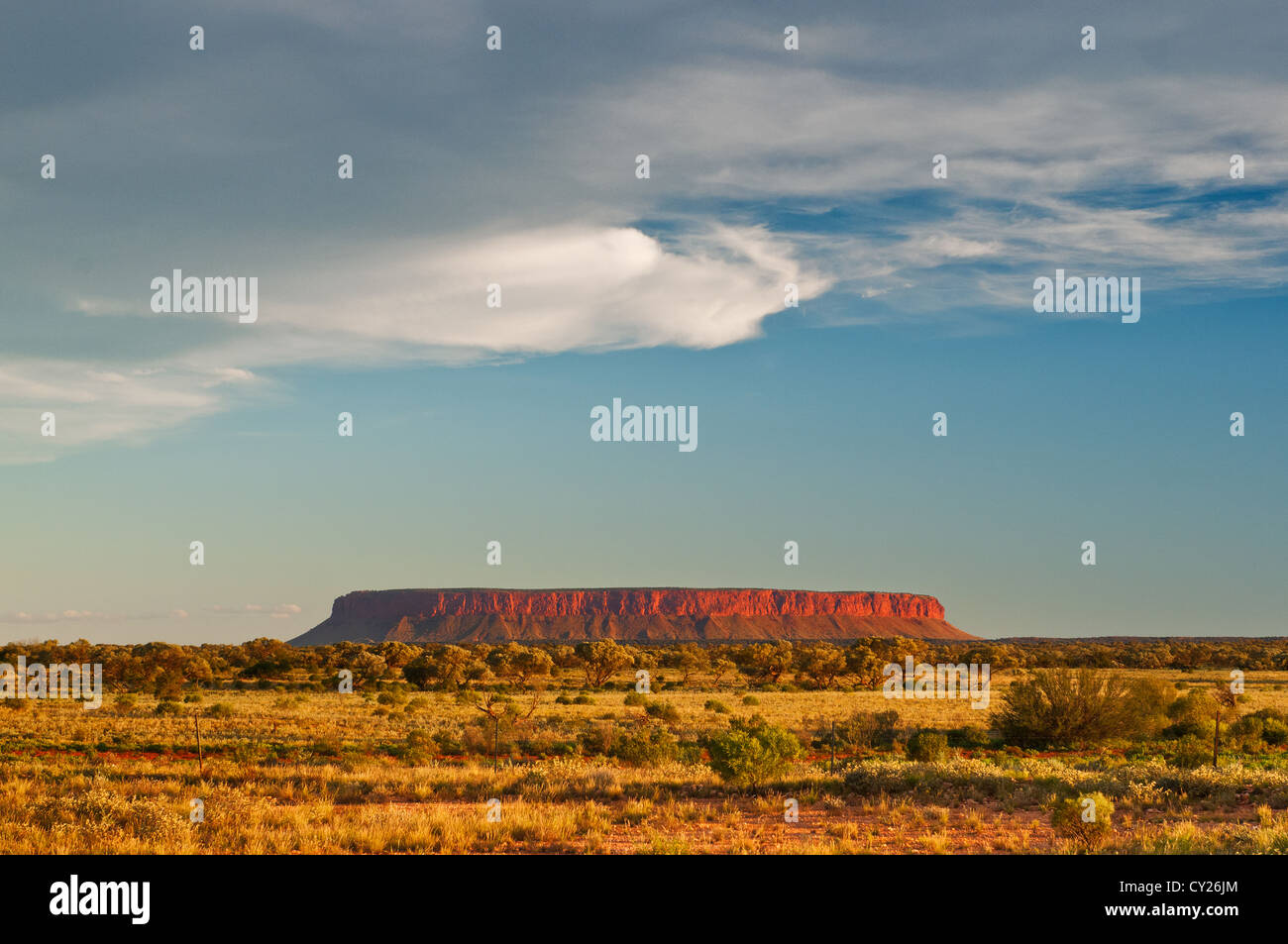 Mount Conner umrahmt von Wolken bei Sonnenuntergang. Stockfoto