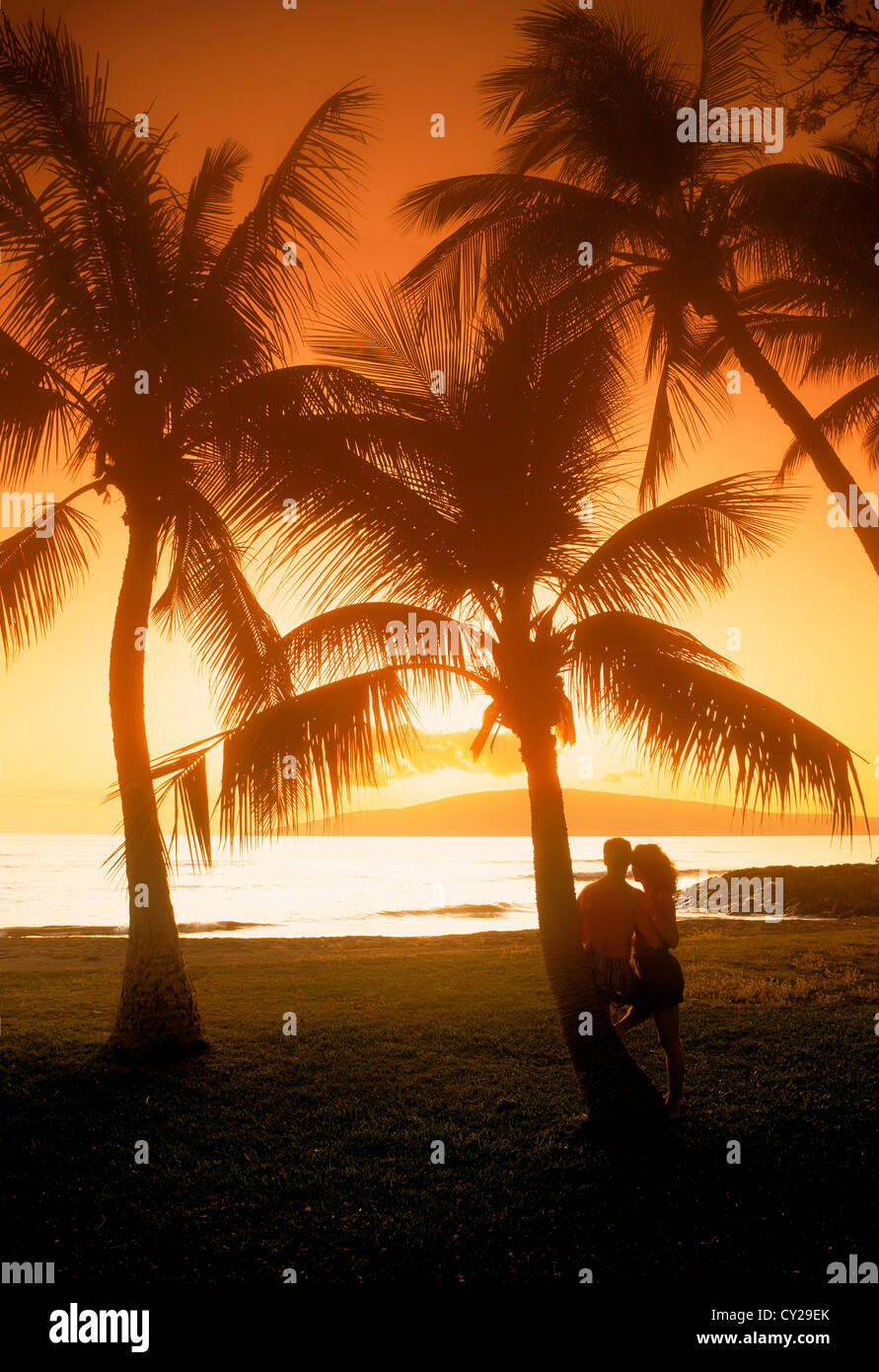 Paar auf Maui mit Sonnenuntergang über entfernte Insel Lanai während der romantischen Hawaii-Urlaub Stockfoto