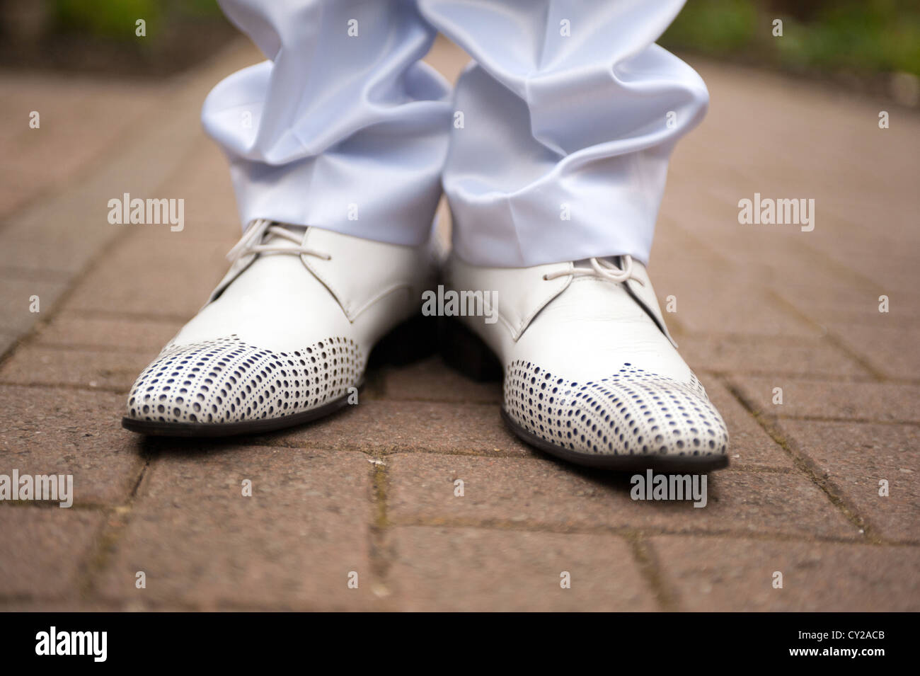 Eine Nahaufnahme von einem Bräutigame Füße in weißen Schuhen Stand auf einem Pflaster Stockfoto