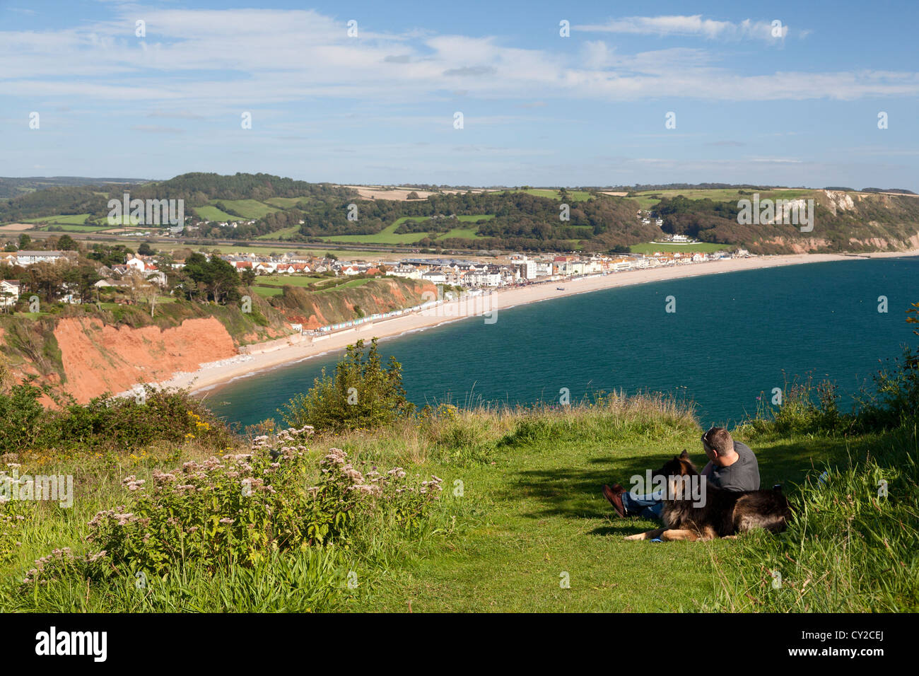 Mann und sein Hund entspannen Sie sich auf die rührende der Jurassic Coast, Seaton, Devon Stockfoto