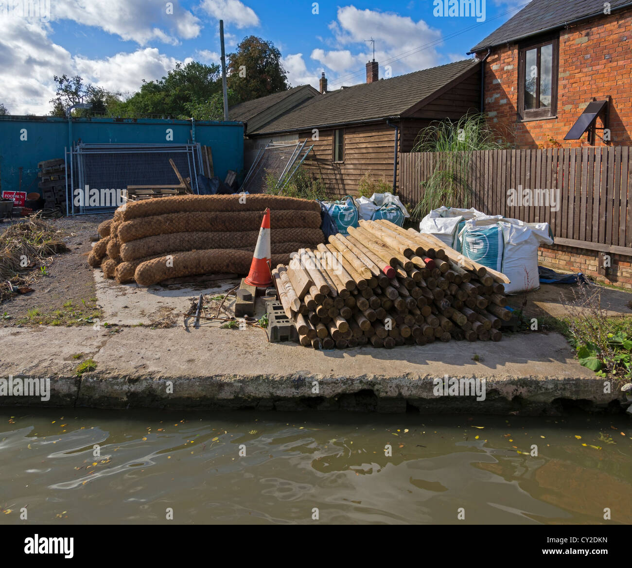 Materialien für die Reparatur des Kanals gestapelt in einem Hof auf der Oxford Union Canal, Oxfordshire. Stockfoto