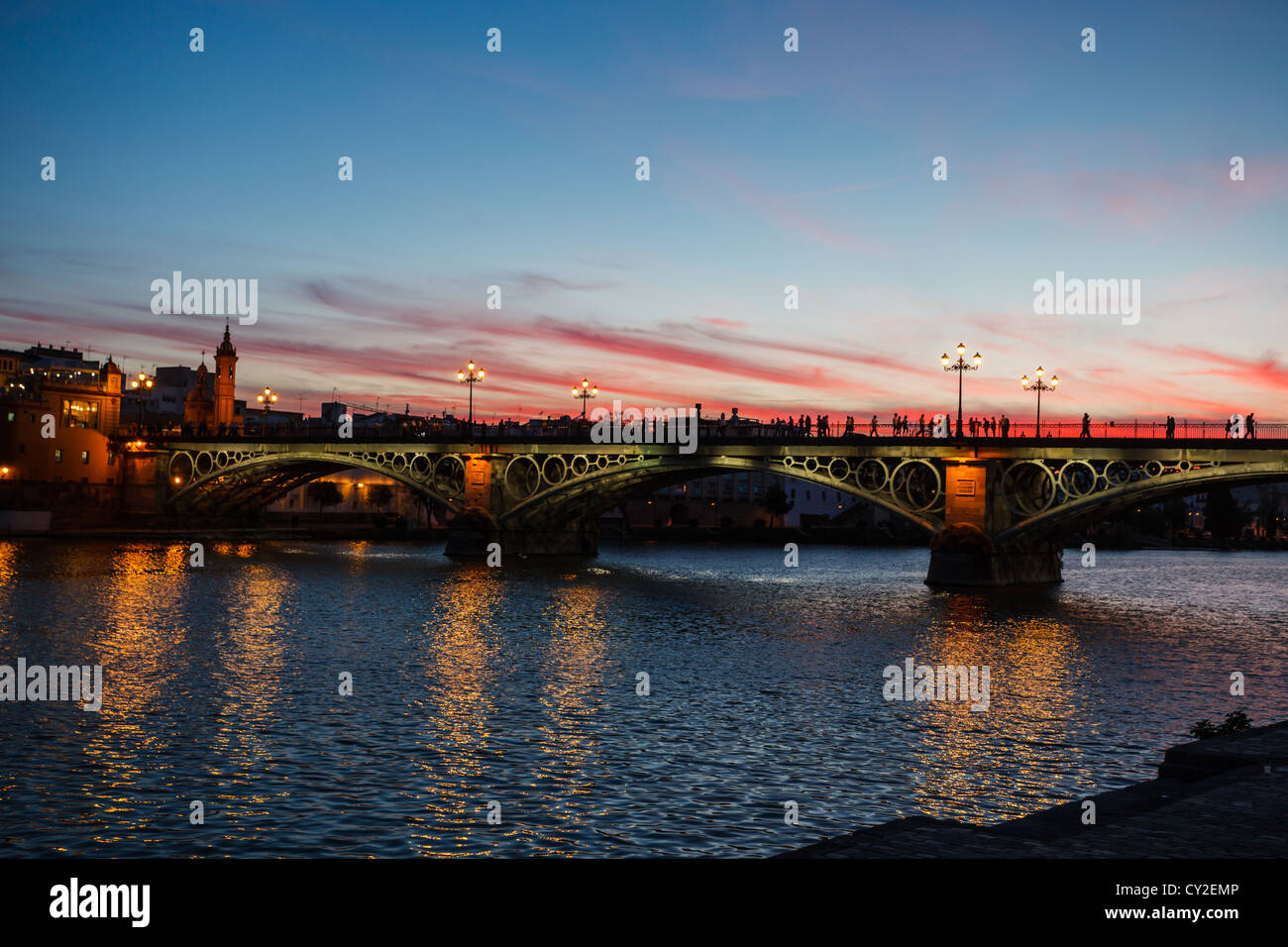 Dämmerung Blick von Isabel II Brücke in Sevilla, Spanien mit Brücke Lichter im Wasser widerspiegelt Stockfoto