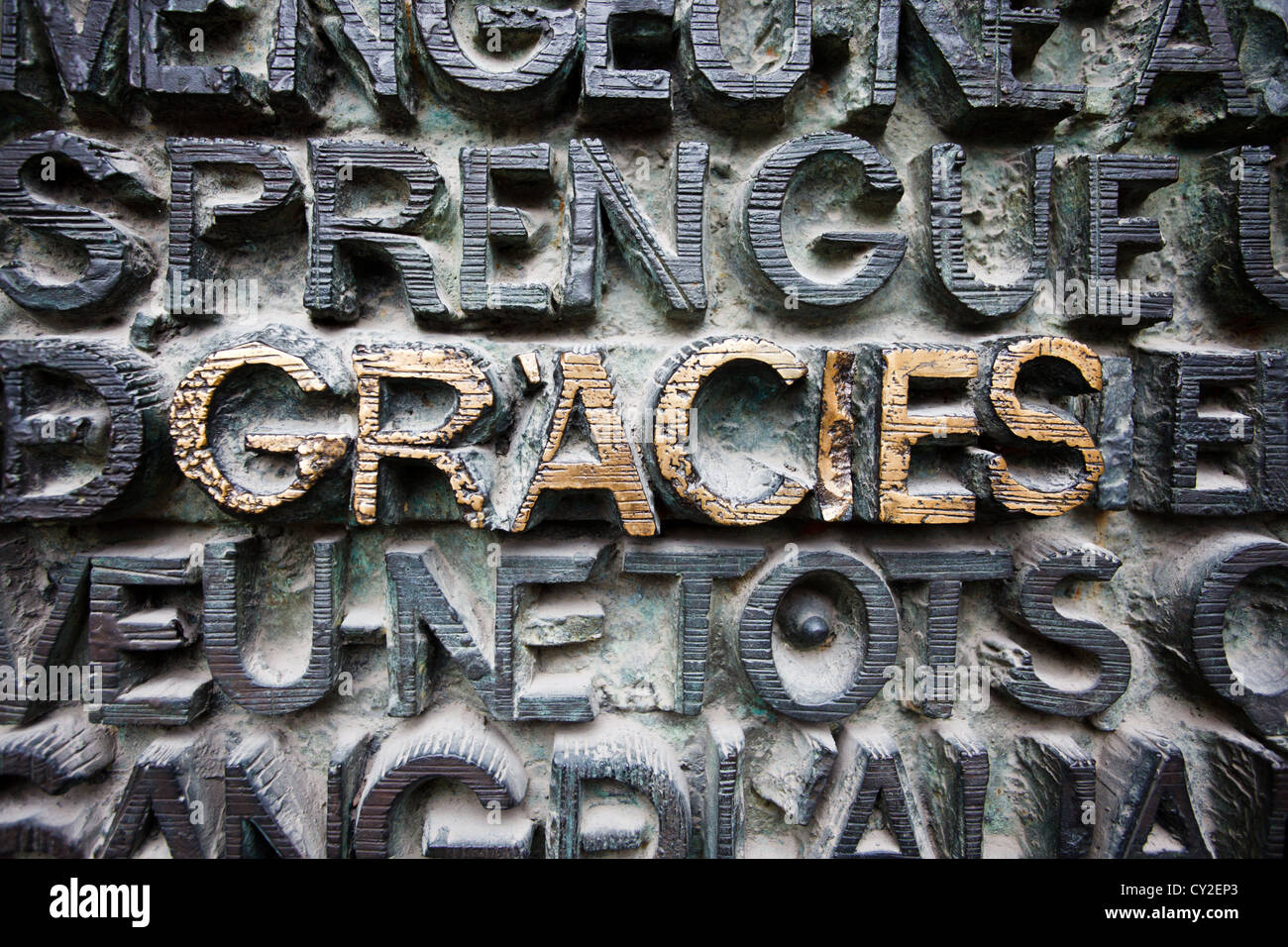 Muster der Bronze angehoben Briefe mit grüne Patina an der Wall Plaque bedeckt, gracies hob in Gold in Sagrada famillia Stockfoto