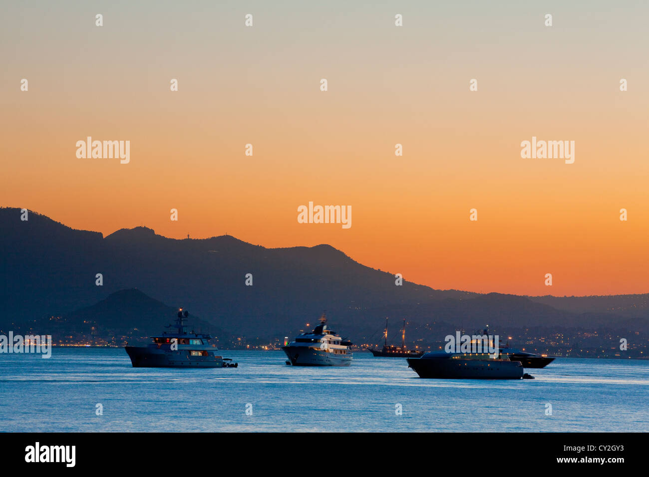 Luxuriöse Yachten in der Bucht von Cannes in der Abenddämmerung, Frankreich Stockfoto