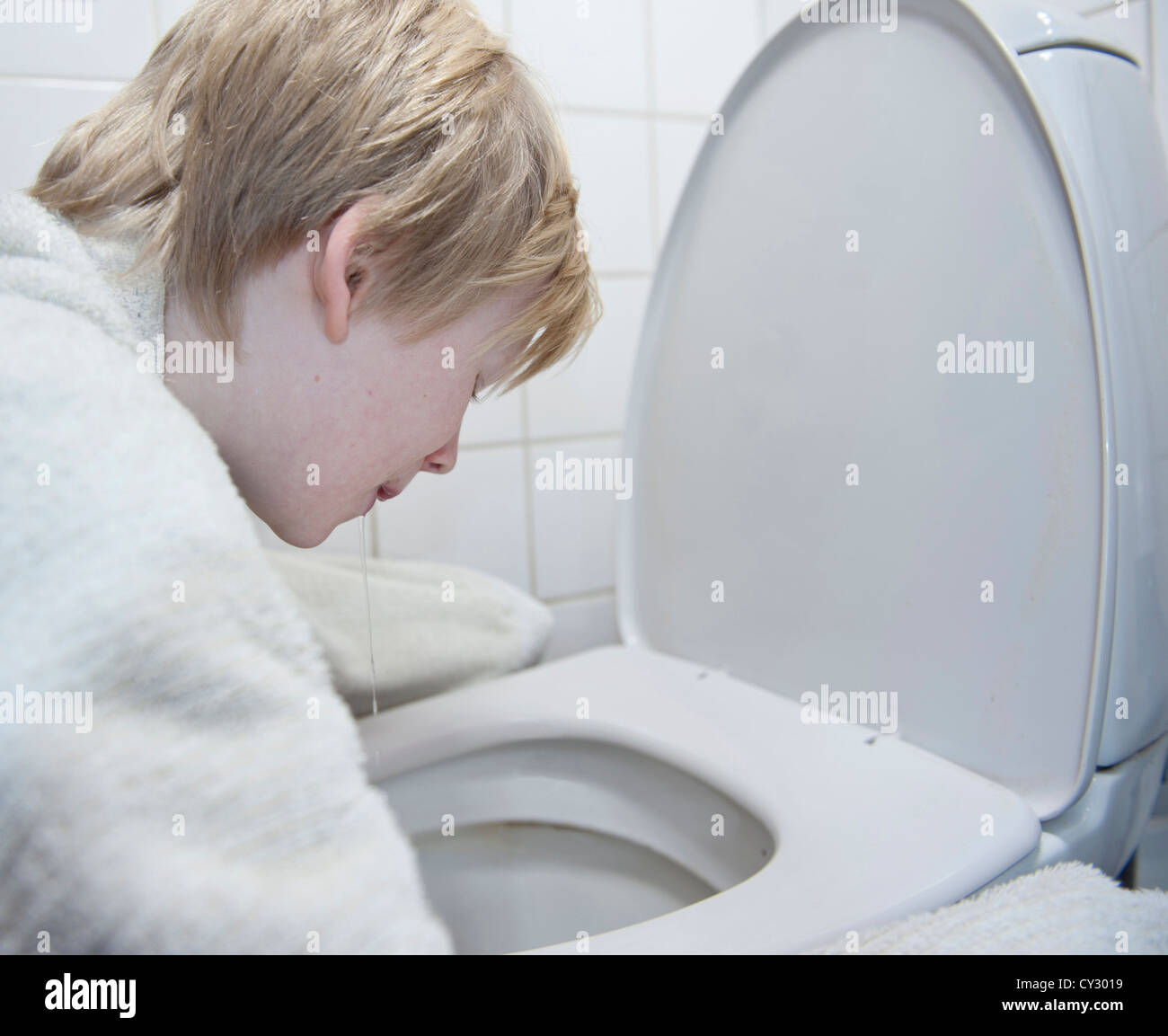 Junge mit Brechdurchfall Erbrechen in Toilette Stockfoto