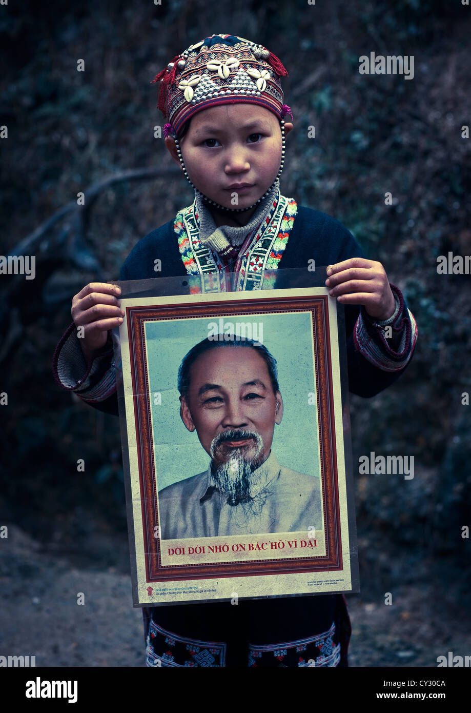 Junge rote Dzao Mädchen zeigt das Porträt von Ho Chi Minh, Sapa, Vietnam Stockfoto