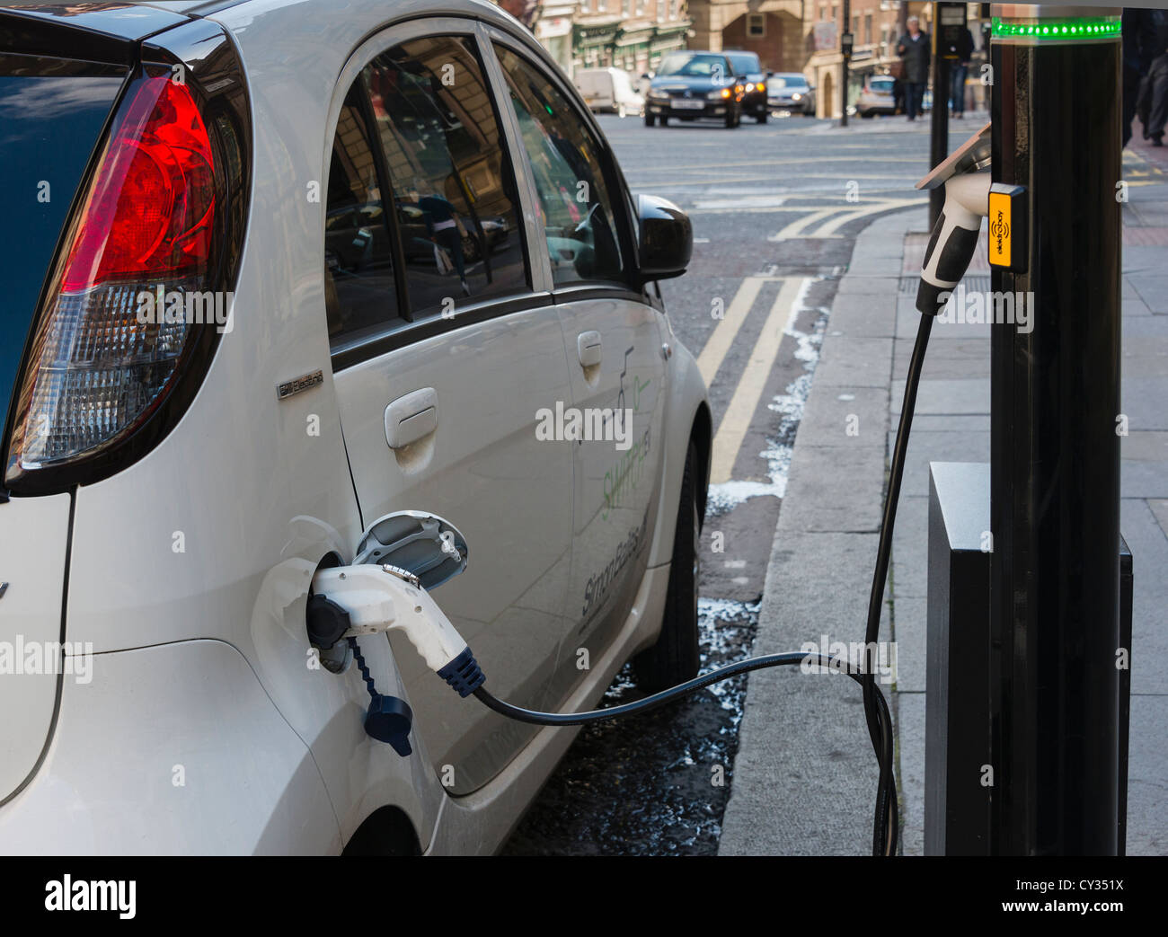 Elektro-Auto auf der Straße, die Ladestation Stockfoto