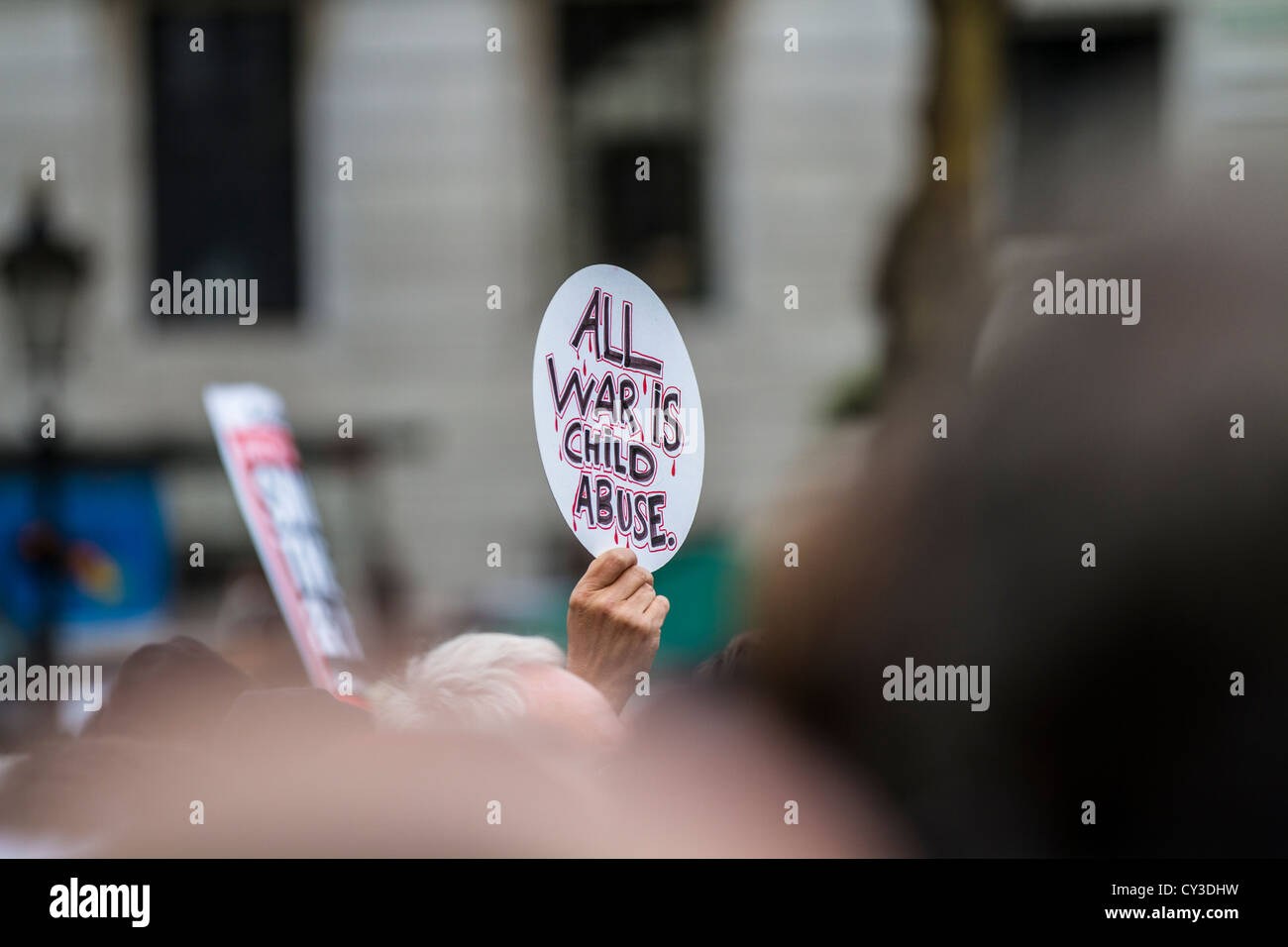 Ein Demonstrant halten ein Schild mit der Aufschrift "jeder Krieg ist Kindesmissbrauch". Die Rallye war der Krieg am Trafalgar Square in London zu beenden. Stockfoto