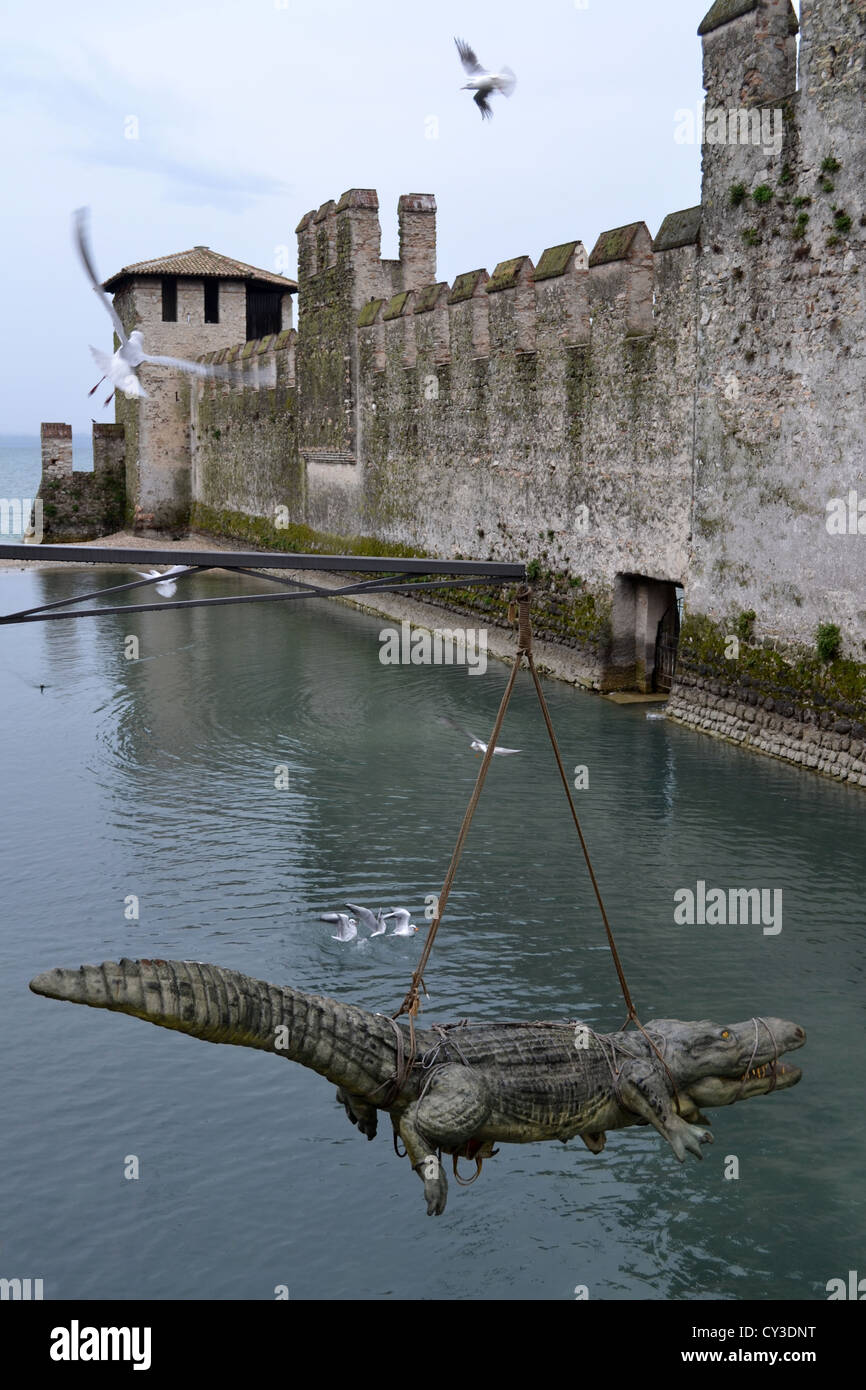 Krokodil-Statue über den Burggraben. Kunstausstellung von Stefano Bombardieri. Sirmione, Gardasee, Brescia, Lombardei, Nord Italien. Stockfoto