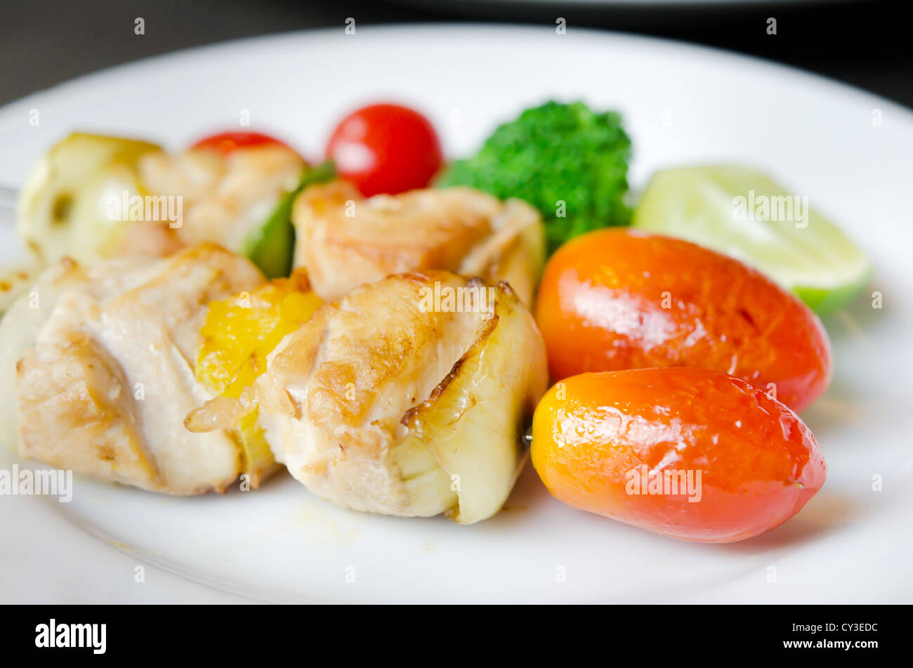 Gegrilltes Schweinefleisch mit Zwiebeln, Paprika, Tomaten und frischem Gemüse Stockfoto
