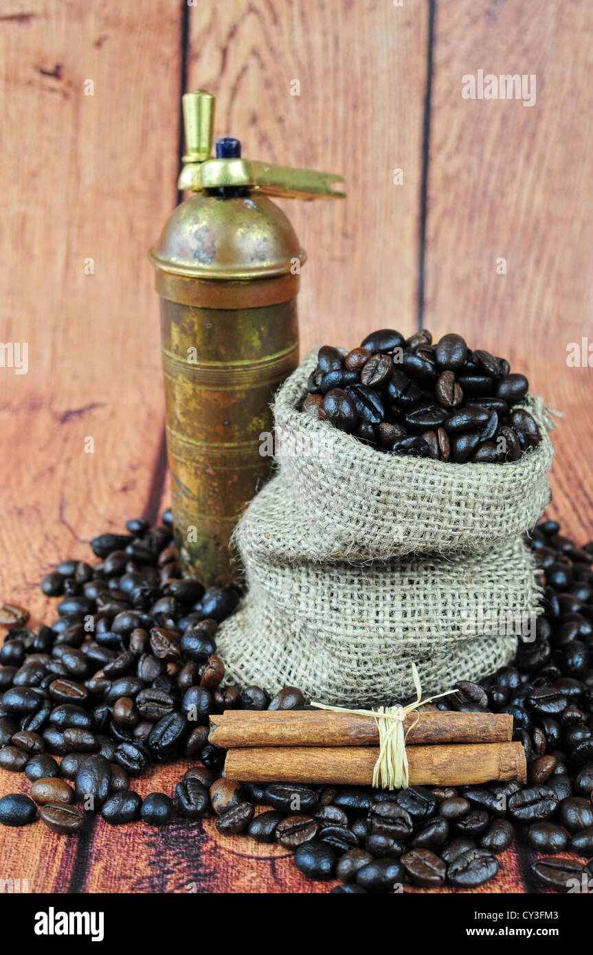 Kaffeebohnen im Leinensack, Vintage Schleifer und Zimtstangen Stockfoto