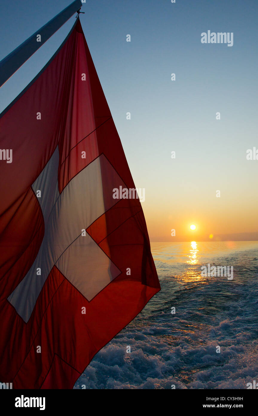 Schweizer Flagge bei Sonnenuntergang auf dem Heck eines Bootes Stockfoto