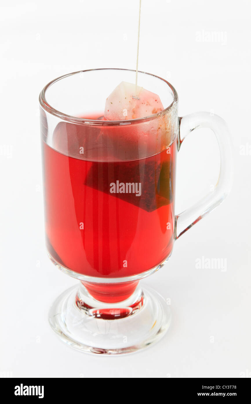 Glas Becher Obst Tee mit Teebeutel auf einem weißen Hintergrund. Großbritannien Stockfoto